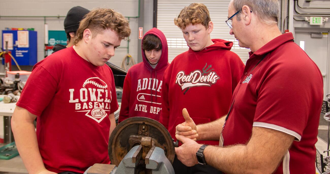 A photo of Lowell High School Red Devil Trades students working with a teacher
